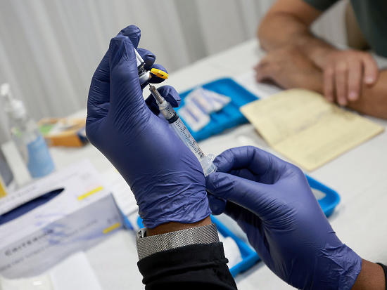 A health-care worker prepares to administer a free monkeypox vaccine in Wilton Manors, Florida. The question: Can vaccination slow the outbreak?