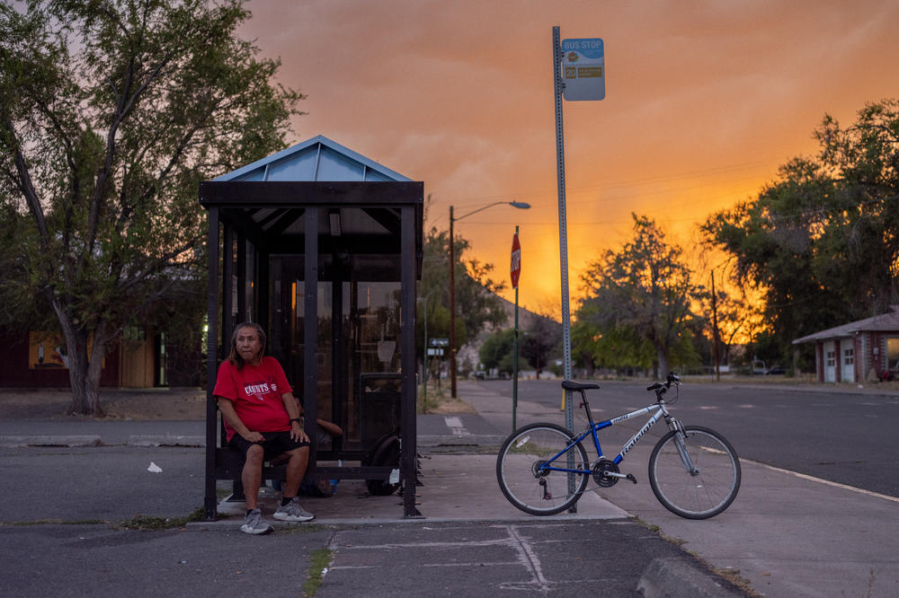 Greg Youngman sits at the route 20 bus stop on the Warm Springs Reservation in Oregon. Public transportation helps residents save money on gas.