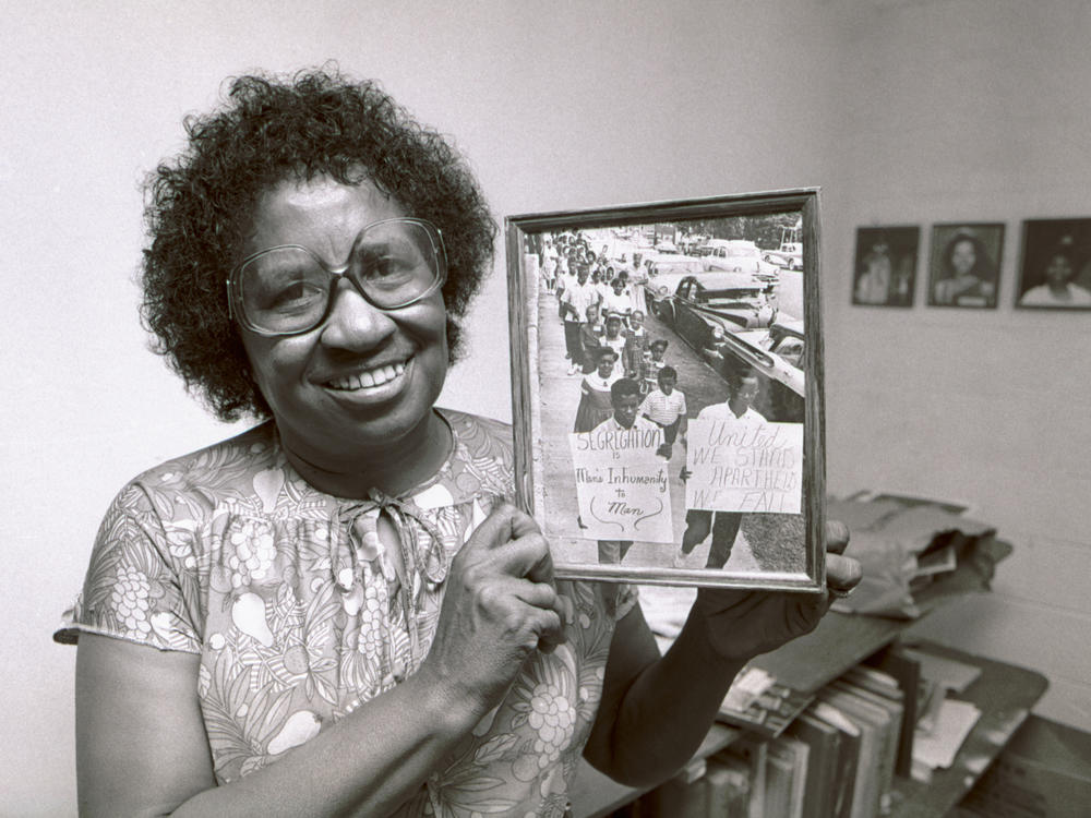 Civil rights leader Clara Luper poses with a photograph from her scrapbooks at a community center in Oklahoma City, Okla., in August 1983.