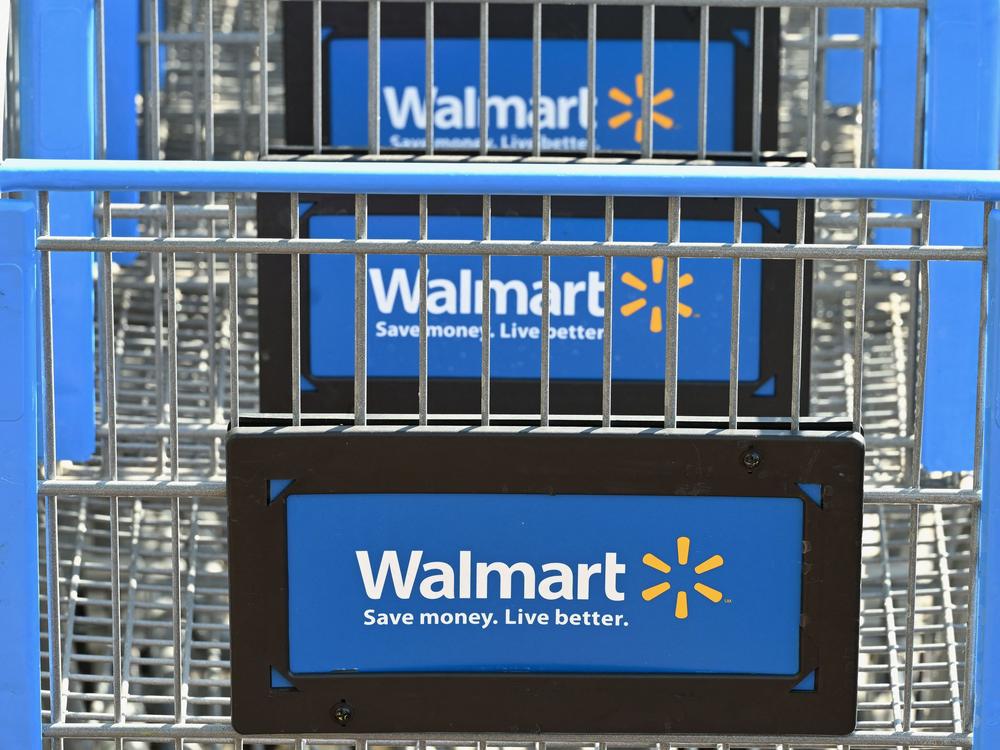 Shopping carts with the Walmart logo are seen outside a Walmart store in Burbank, Calif. on Aug. 15. Walmart experienced a decline in earnings in the most recent quarter.