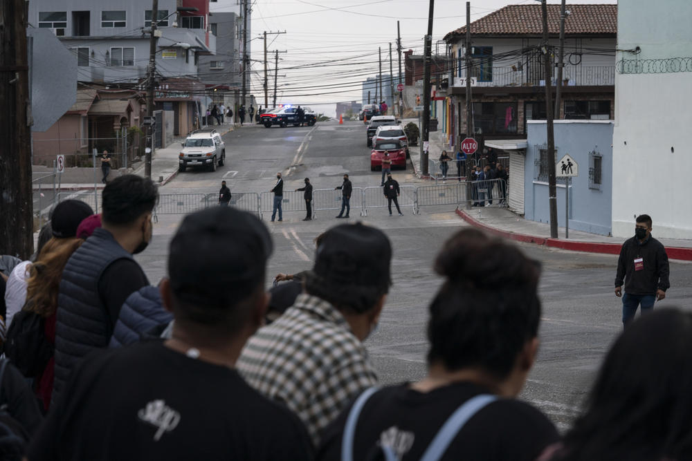 Police stand guard as people take part in the peaceful rally outside the military base.