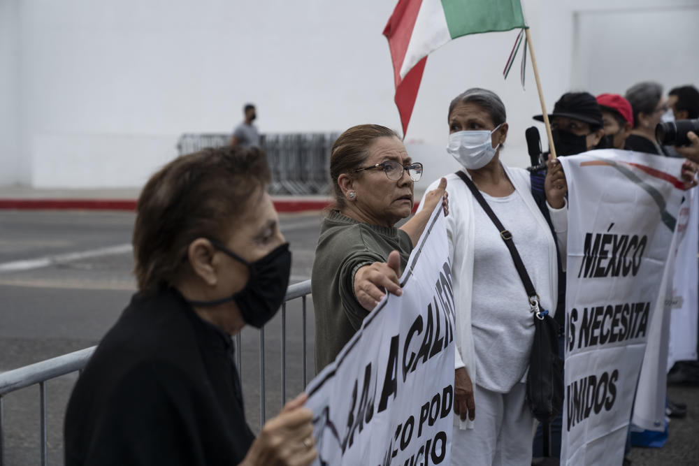 Tijuana residents take part in a peaceful rally outside a military base during a visit by Mexico's president.