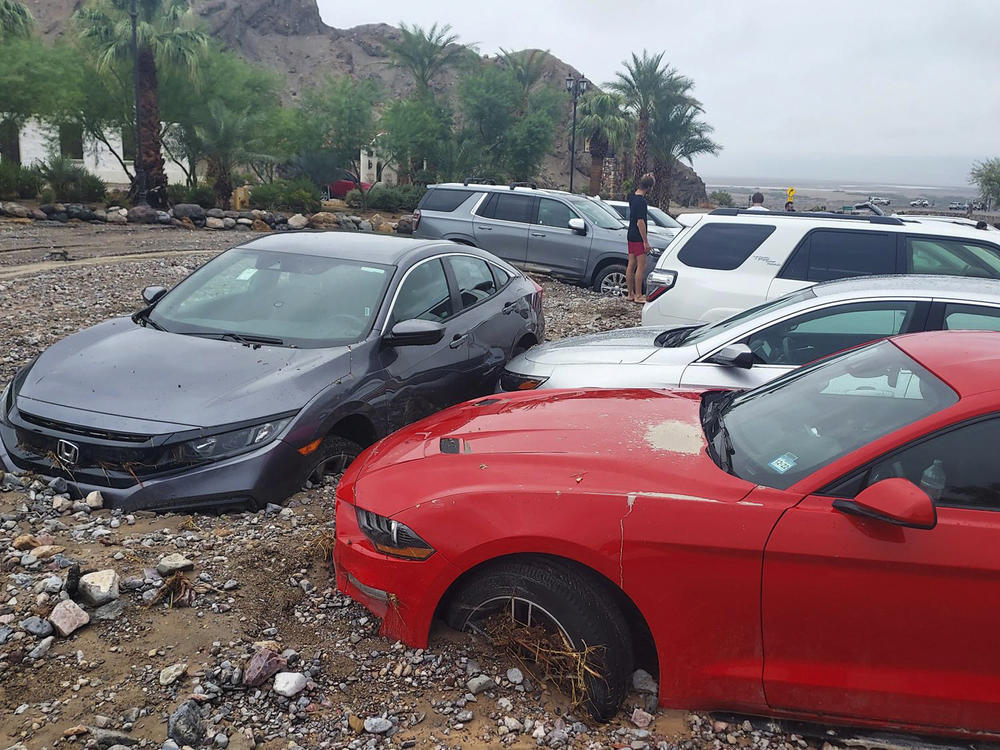 In this photo provided by the National Park Service, cars are stuck in mud and debris from flash flooding at The Inn at Death Valley in Death Valley National Park on Aug. 5, 2022.