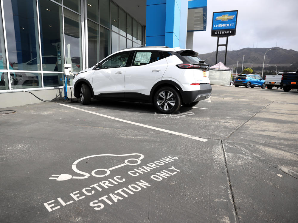 A brand new Chevrolet Bolt sits on the sales lot at a car dealership in Colma, Calif., on Oct. 7, 2021. President Biden's climate and health care bill revamps a tax credit available for buyers of electric cars.