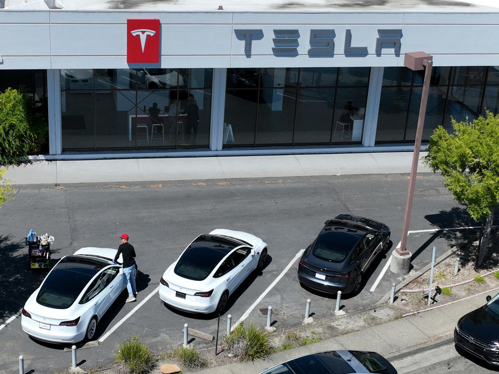 New Tesla cars sit on a parking lot at a Tesla showroom in Corte Madera, Calif., on June 27. Companies like Tesla or General Motors that have been producing cars in the U.S. and have already shifted their supply chains are better placed to meet the requirements of the revamped tax credit for electric car purchases.