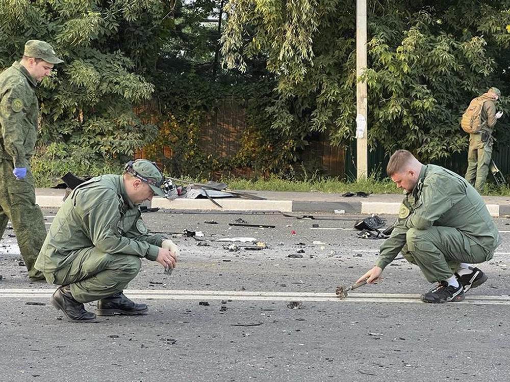 Investigators work at the site of a car explosion that killed Daria Dugina outside Moscow. She was the daughter of a key Putin ally.