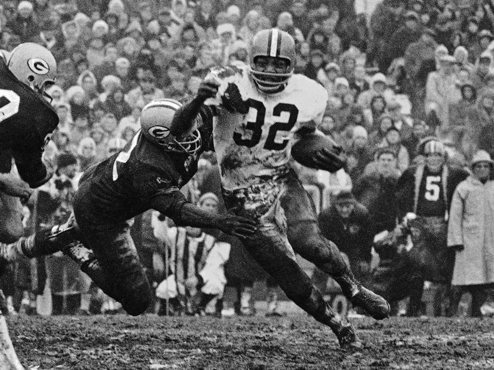 In this Jan. 2, 1966, file photo, Cleveland Browns' Jim Brown (32) turns the corner as a Green Bay Packer defender swings with him during a football game in Green Bay, Wisc.