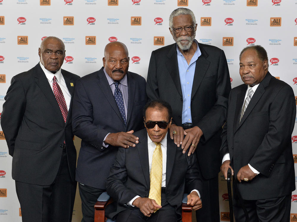 In this Sept. 27, 2014, file photo, back row from left, John Wooten, Jim Brown, Bill Russell, and Bobby Mitchell stand behind Muhammad Ali. In 1967, all five of these men attended 