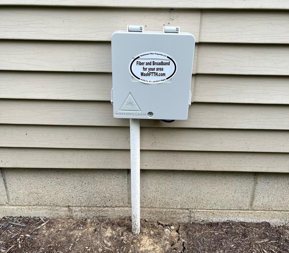 One of Mauch's customer boxes with fiber cable is hooked up to the side of a home.