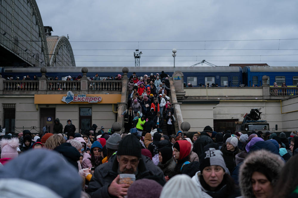 Ukrainians displaced by war pour out of the Lviv train station in March.