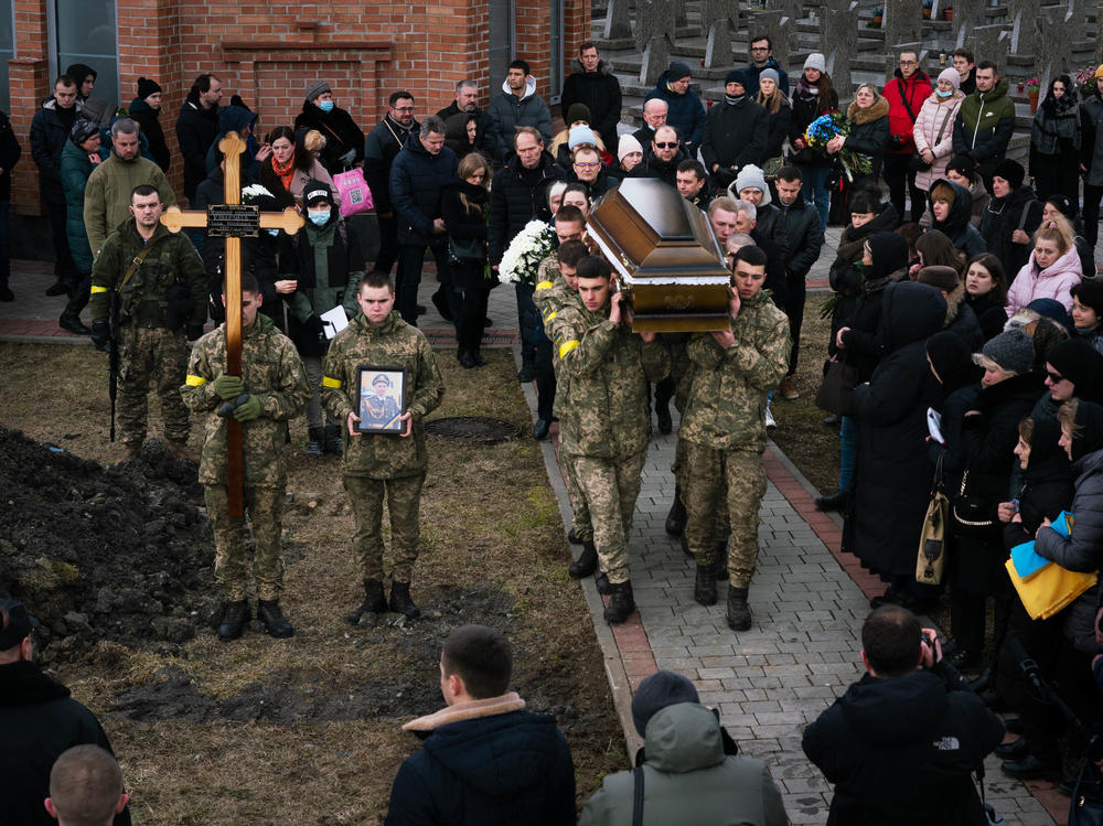 A funeral procession in Lviv, Ukraine, in March ends at grave sites where soldiers Viktor Dudar, 44, and Ivan Koverznev, 24, will be buried, as priests say their blessings and mourners look on.