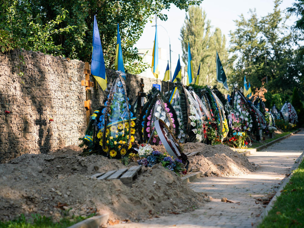 New graves and freshly dug holes for Ukrainian soldiers line the edge of a cemetery in Kyiv on Aug. 24.