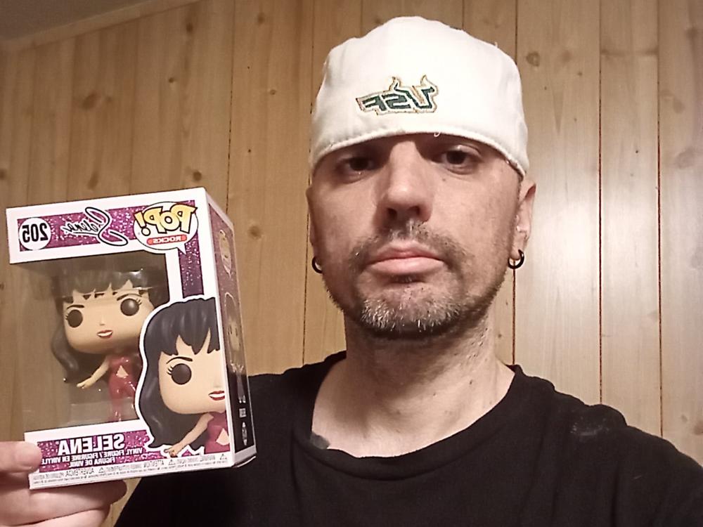 Selena fan Brandon Hunter of Tampa, Florida poses with a Selena toy.