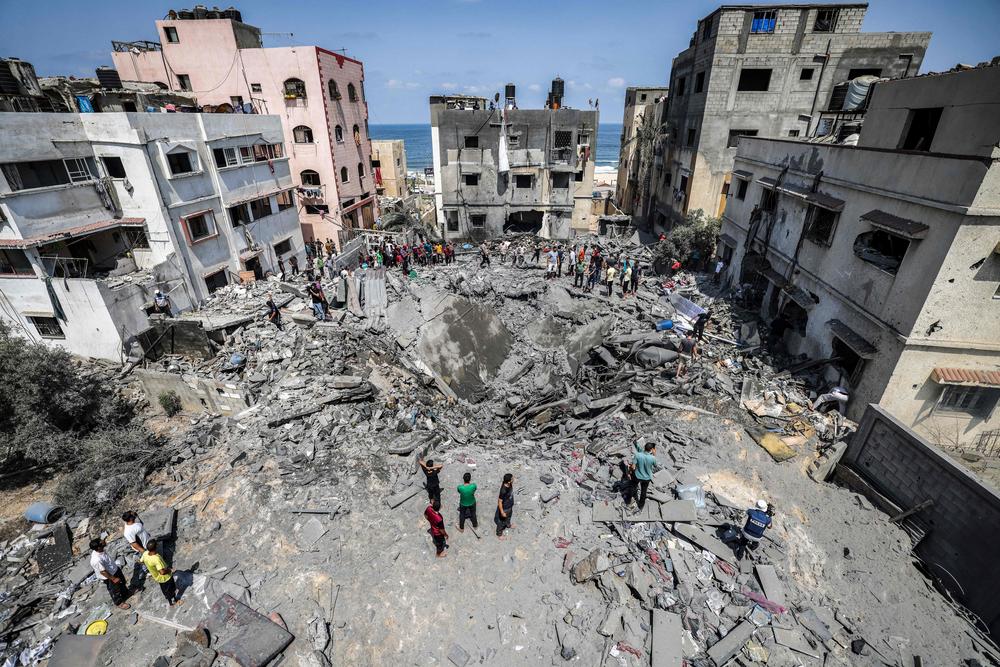 Palestinians inspect the ruins of a collapsed building destroyed by an Israeli air strike in Gaza City, on Aug. 6.