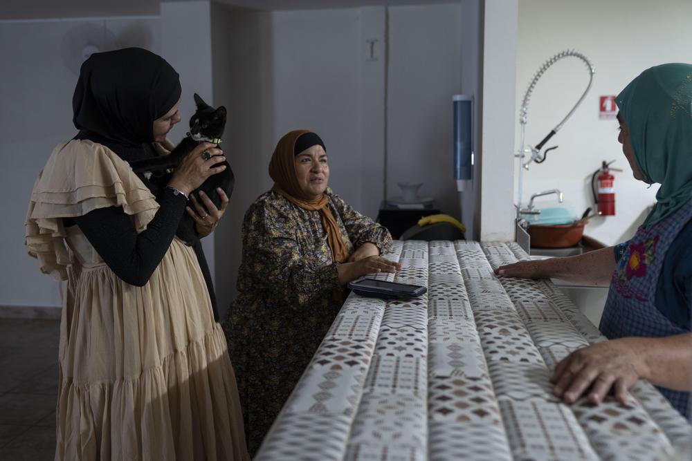 Sonia García, president of the Latina Muslim Foundation, plays with a cat at the Assabil shelter for Muslim migrants in Tijuana.