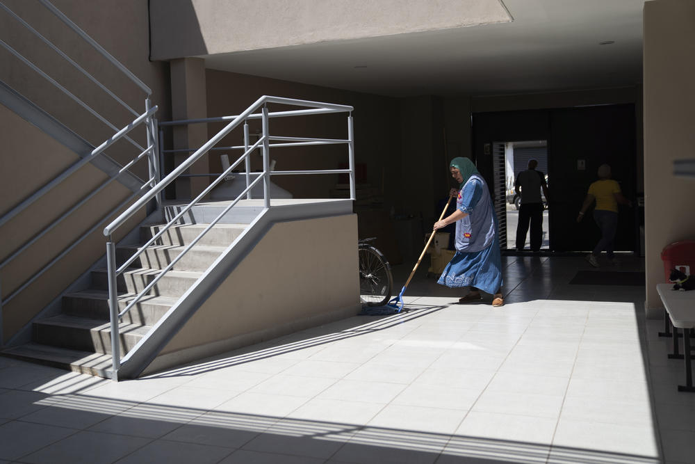 Fátima Zagada, in charge of the kitchen and cleaning duties, cleans the floor before Friday prayer.