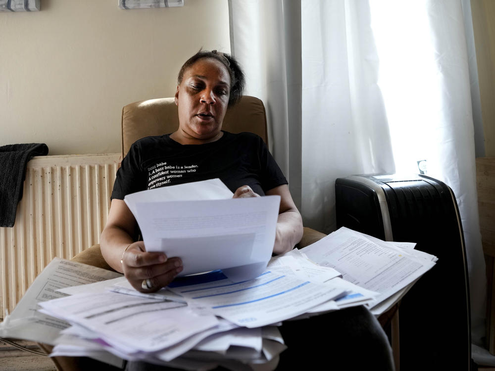 Jennifer Jones sorts her bills at her small flat in London, Thursday, Aug. 25, 2022. Like millions of people, Jones, 54, is struggling to cope as energy and food prices skyrocket during Britain's worst cost-of-living crisis in a generation.
