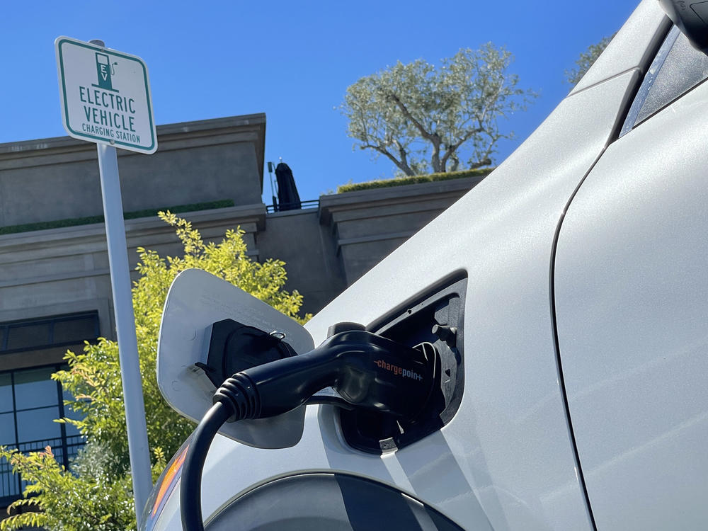 An electric car charges at a mall parking lot in Corte Madera, Calif., on June 27. The lack of charging infrastructure is seen as one of the key roadblocks to adopting electric cars.