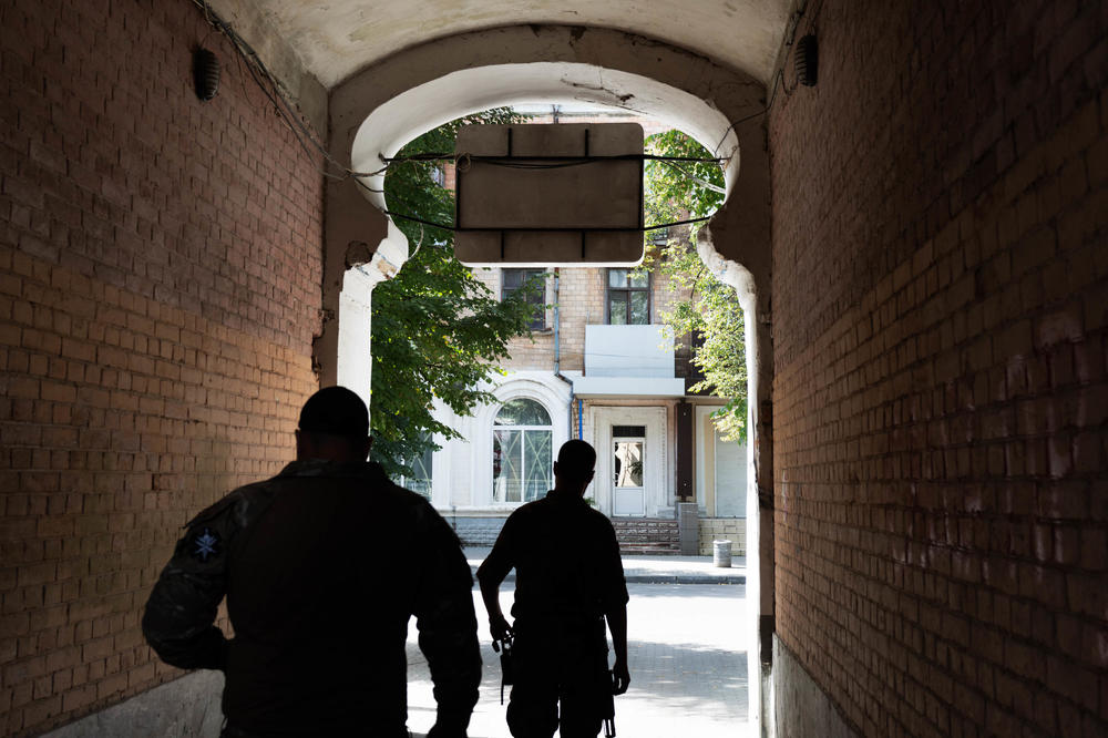 Soldiers walk through the entryway to a coffee shop in downtown Slovyansk.