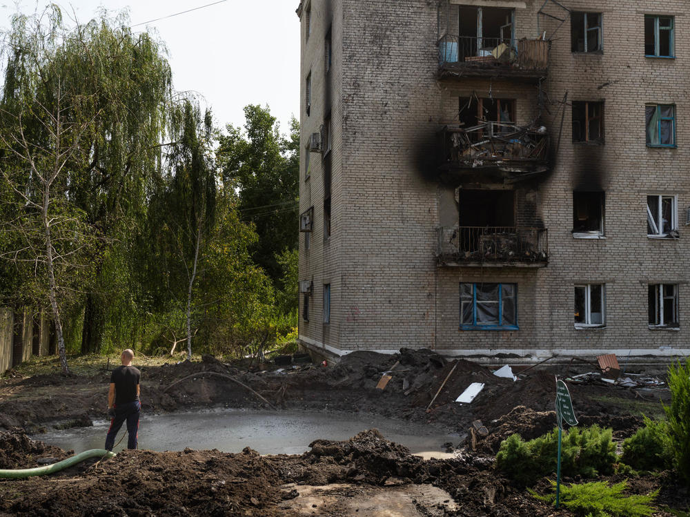 A man stands in front of a crater that was made from a missile strike in Slovyansk on Sunday morning.
