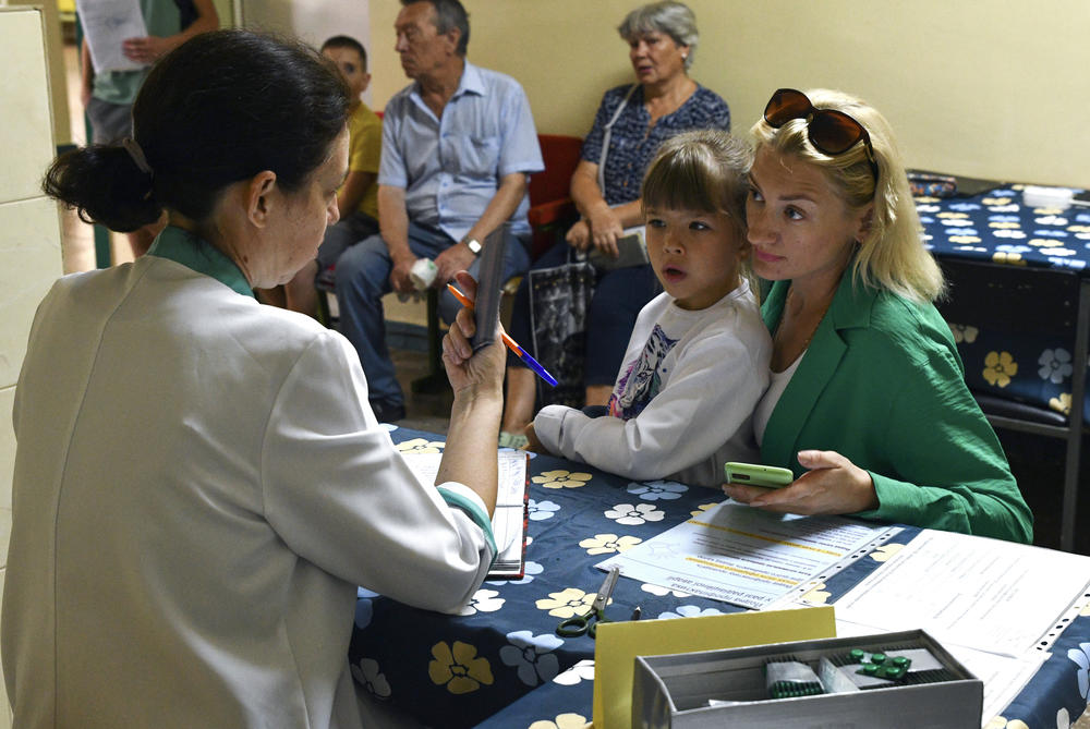 People receive tablets containing iodine in Zaporizhzhia, Ukraine, Aug. 26. A mission from the International Atomic Energy Agency is expected to visit the Zaporizhzhia nuclear power plant this week after it was temporarily knocked offline and shelling has been reported in the area.