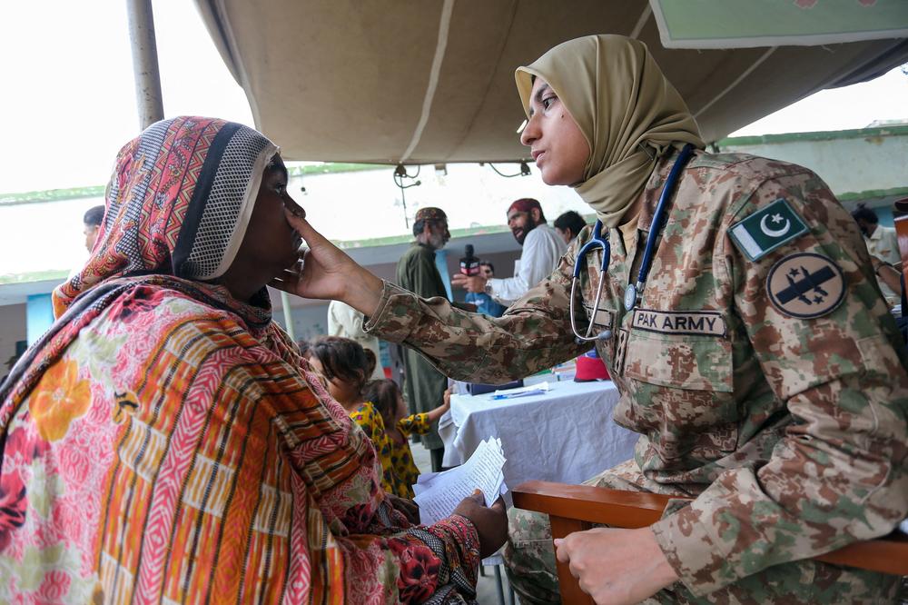 An army doctor checks a woman at a makeshift hospital in the flood-affected Rajanpur district in southern Punjab province, on Aug. 2.