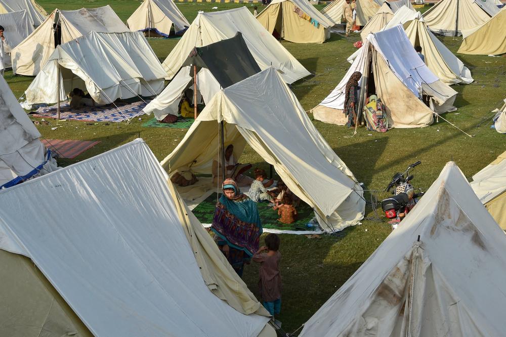 Displaced people sit in tents at a makeshift camp after fleeing their homes following heavy monsoon rains in Charsadda district, Khyber Pakhtunkhwa province, on Aug. 29. The death toll from monsoon flooding in Pakistan since June has reached more than 1,000, according to the country's National Disaster Management Authority.