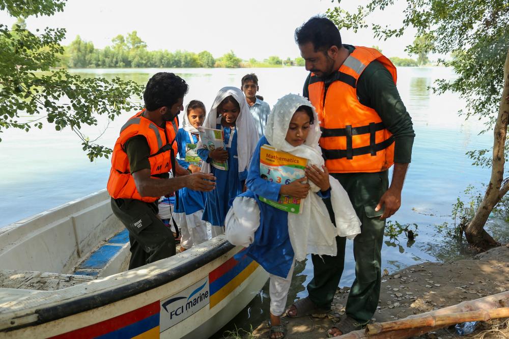Children alight from a boat as they return home after school in a flood hit area following heavy monsoon rains in Dera Ghazi Khan district in Punjab province on Aug. 29.