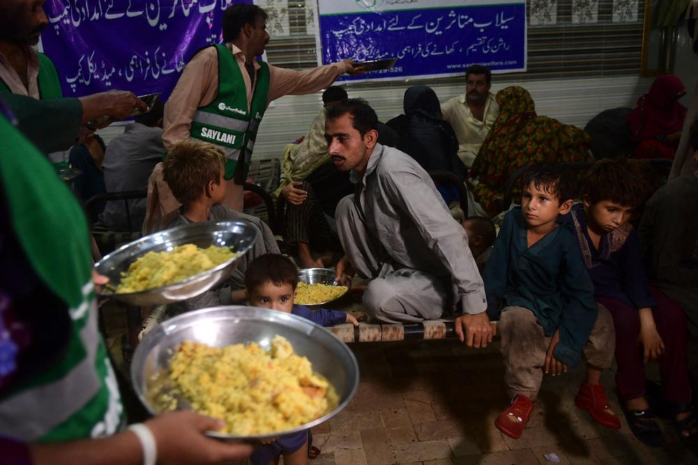 Volunteers with the Saylani Welfare International Trust charity distribute food to displaced people in an area hit by floods in Sukkur, Sindh province, on Aug 29.