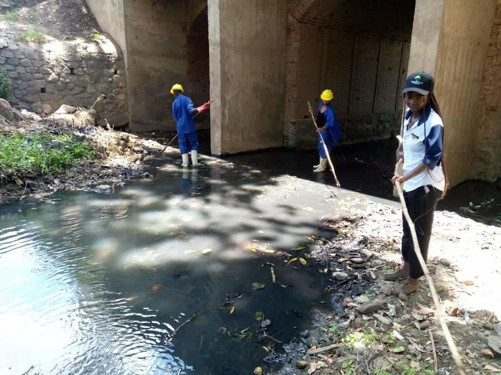 Volunteers with Art Malawi, a local arts organization, clean plastic litter and debris from the Mudi River in Blantyre, Malawi. Volunteers worked for months to clean up the river.