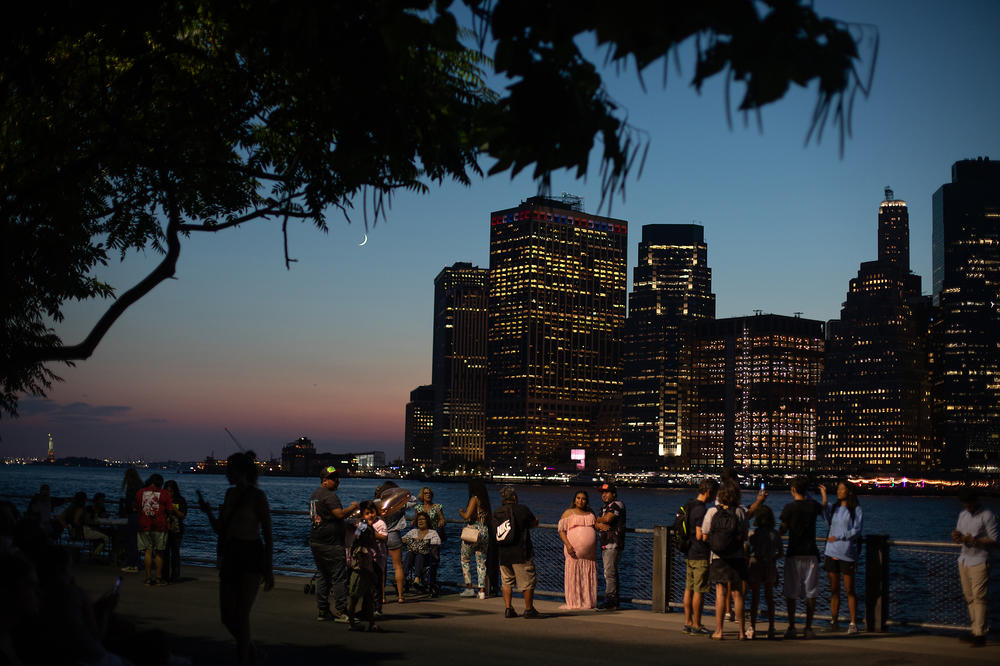 Trees and other plants help keep cities cooler. In New York City, scientists are working to understand how to maximize the benefits of urban green spaces. Here, residents gather in Brooklyn Bridge Park on a hot summer night.
