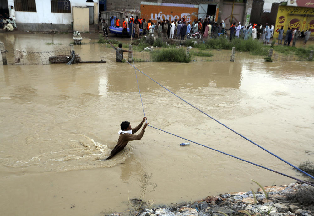 A man wades through a flooded area on the outskirts of Peshawar, Pakistan, on Aug. 27.
