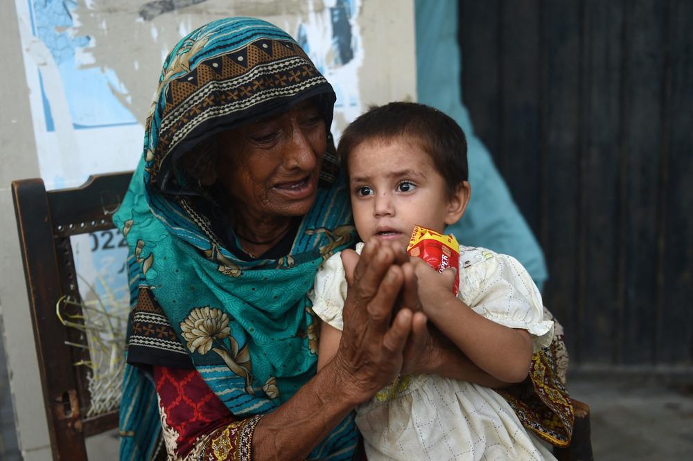 After being evacuated from home, a woman and child take refuge at a school in Karachi on Aug. 25.