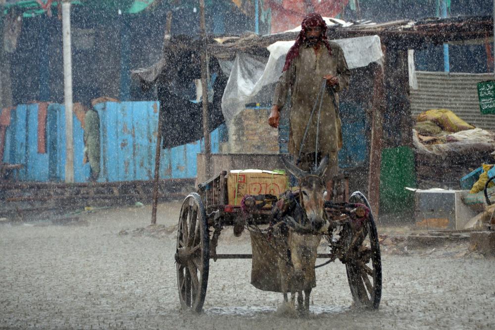 A man rides on his donkey cart during heavy rainfall in the flood-hit town of Dera Allah Yar in Jaffarabad district, Balochistan province, on Aug. 30.