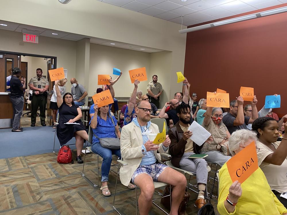 Anti-censorship protestors at a meeting of the Lafayette Library Board, defending a librarian who included queer teen dating in a book display in defiance of the board.