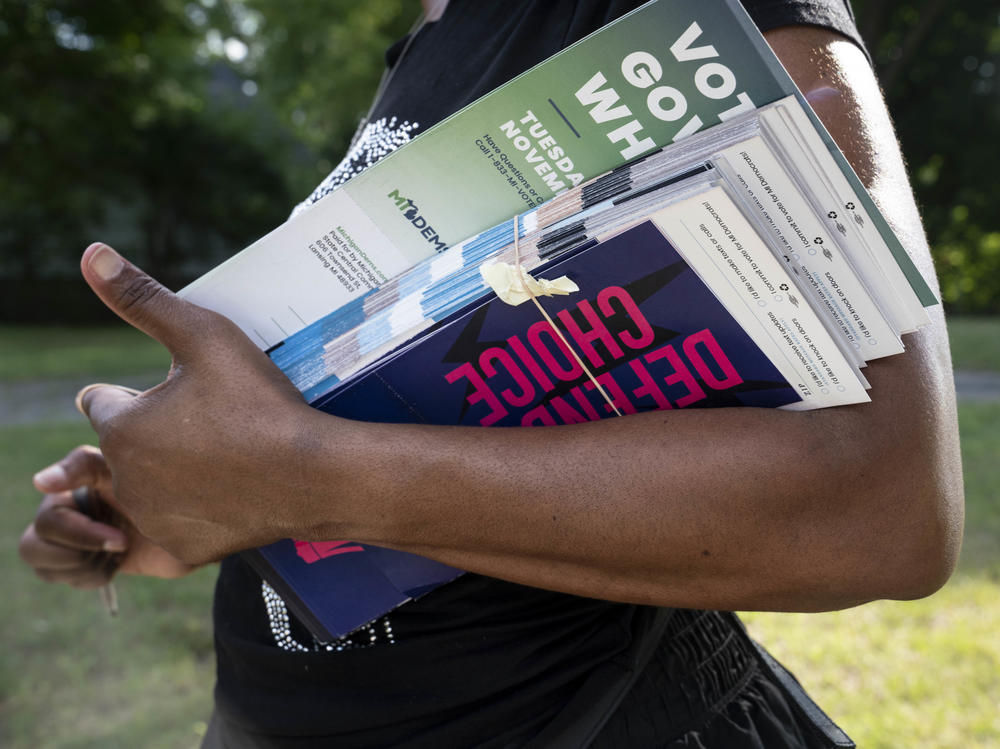 Regina Campbell holds her paperwork for knocking on doors to tell residents about issues on the ballot in the fall, including a potential constitutional amendment on reproductive rights, in Pontiac, Mich., on August 6, 2022.