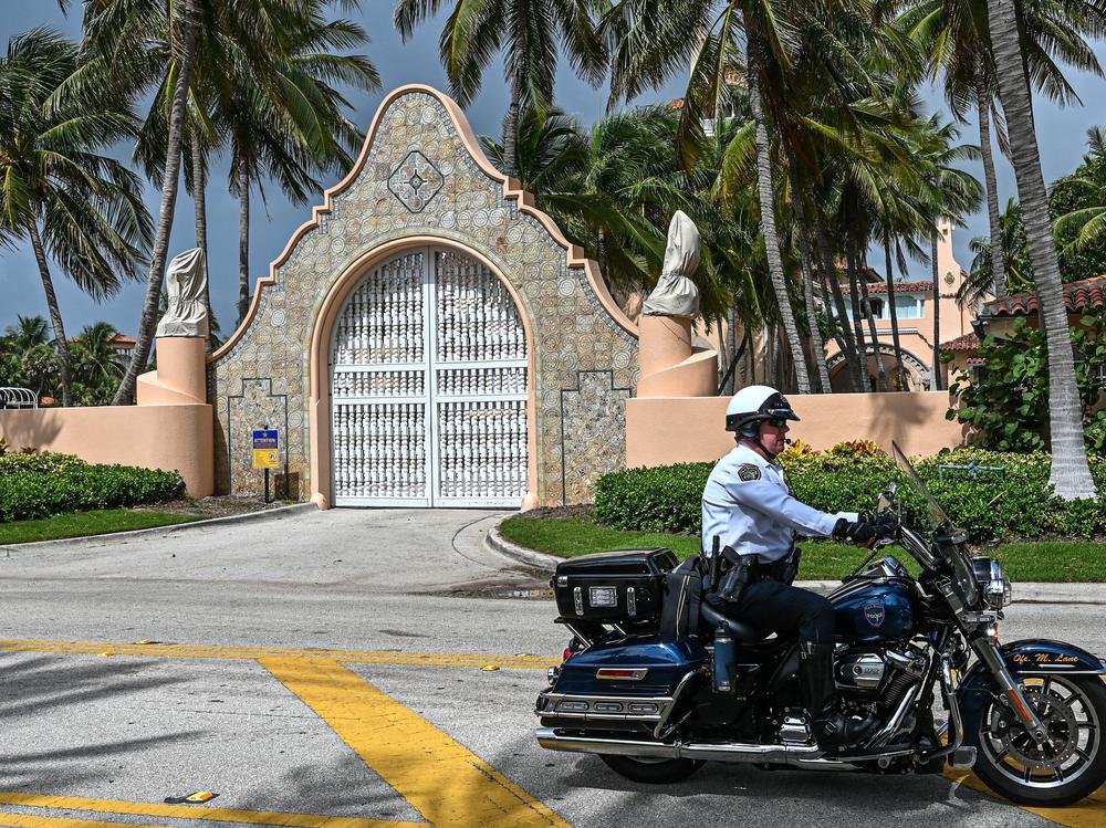 A local law enforcement officer is seen in front of the home of former President Donald Trump's Palm Beach, Fla., home, on Aug. 9, the day after it was searched by FBI agents for classified documents.
