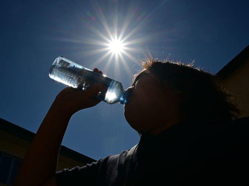 A child sips water from a bottle under a scorching sun on Tuesday in Los Angeles. Forecasters say temperatures  could reach as high as 112 degrees in the densely populated Los Angeles suburbs in the next week as a heat dome settles in over parts of California, Nevada and Arizona.
