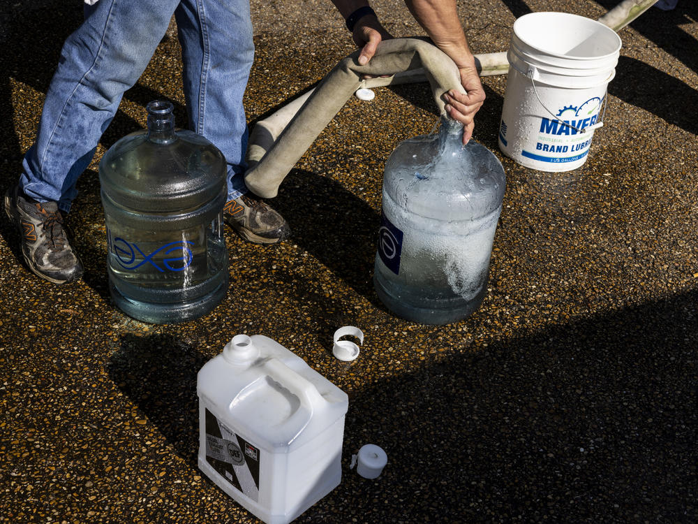 Ty Carter fills containers with nonpotable water on Aug. 31 in Jackson, Mississippi. The state's capital is struggling with access to safe drinking water after historic rain and flooding led to a drop in pressure at Jackson's main water-treatment plant on Aug. 29.