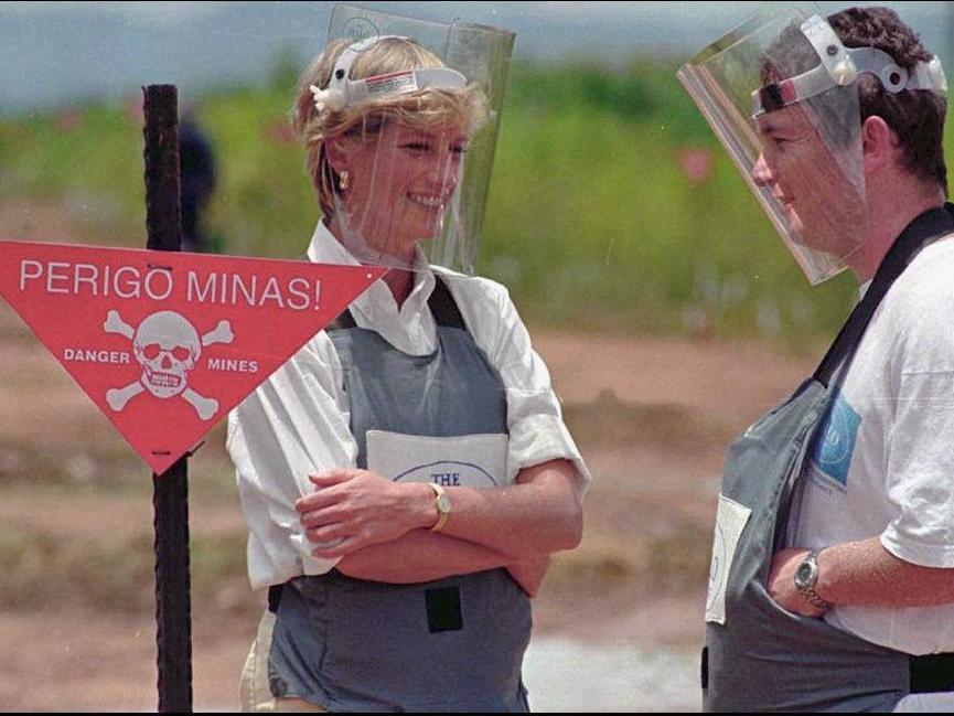Princess Diana, wearing a heavy duty protection vest and face shield, visits mine fields near Huambo, Angola.