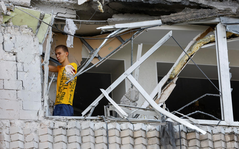 A local resident removes debris inside an apartment building damaged by shelling in the course of Ukraine-Russia conflict in the Russian-controlled city of Enerhodar, in the Zaporizhzhia region, on Thursday.