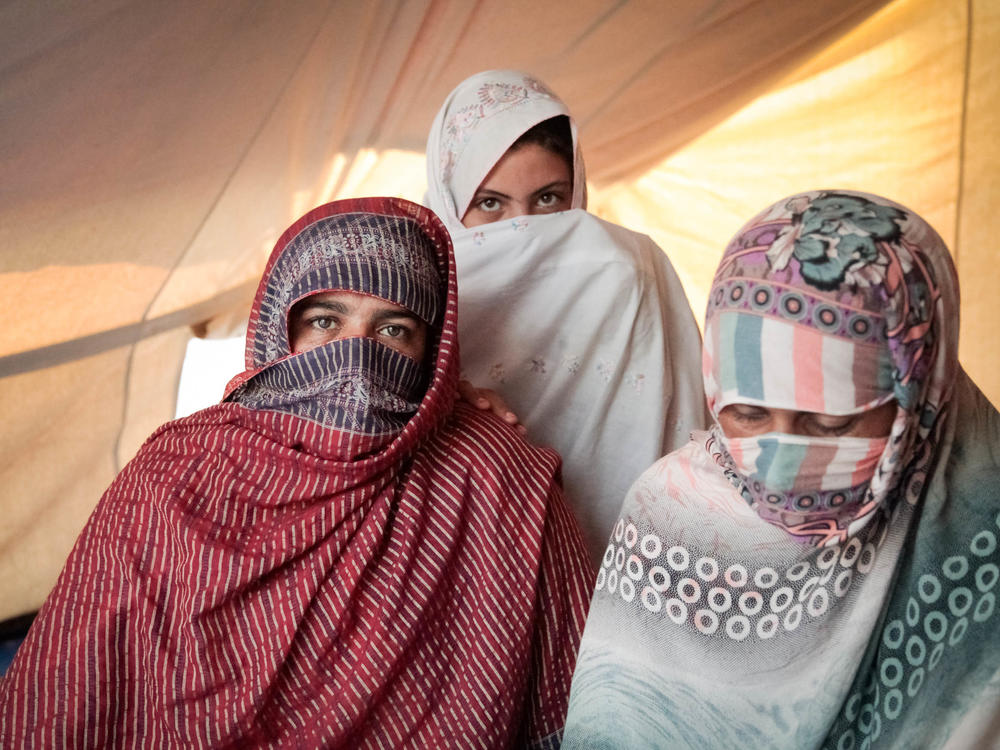 Left to right: Nazia, Mubina and Leila saw their homes washed away in the flooding. They now share a tent at a technical college that has been converted into a camp for displaced people.