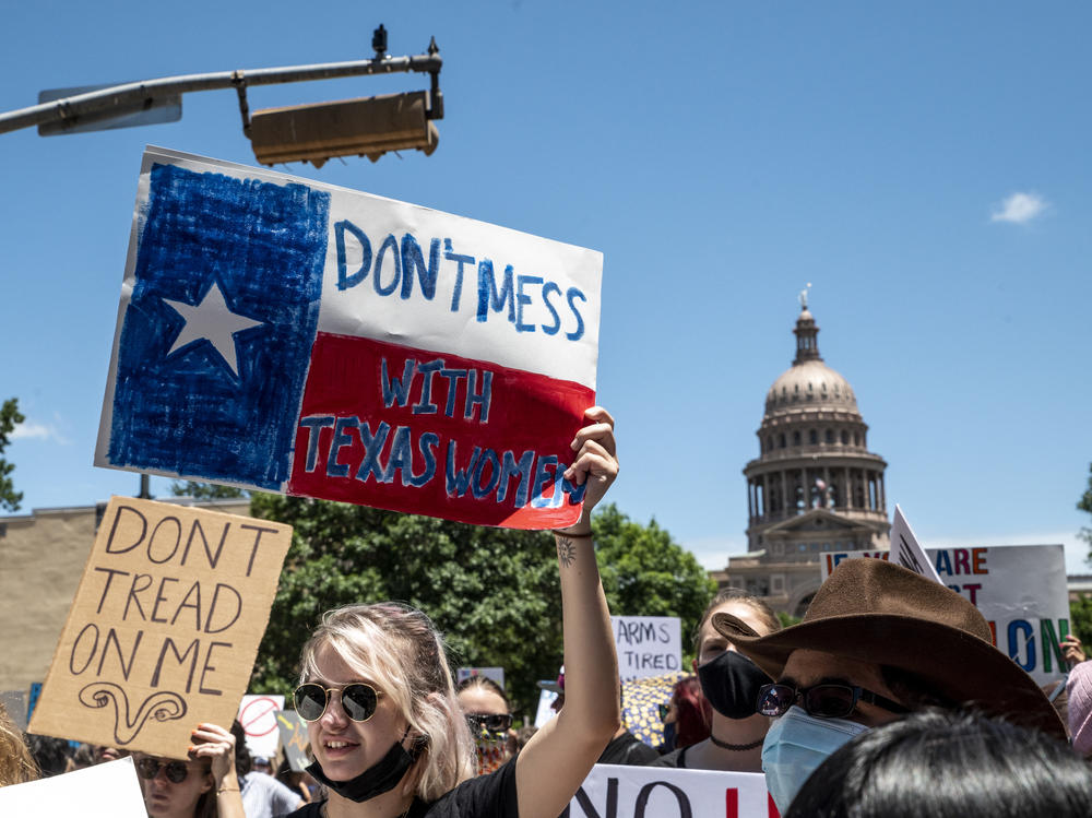 Protesters hold signs as they march in opposition to the anti-abortion law S.B. 8 outside the Texas state capitol on May 29, 2021 in Austin.