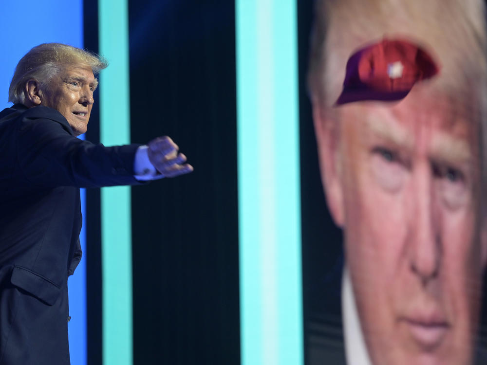 Former President Donald Trump tosses hats into the crowd before addressing attendees during the Turning Point USA Student Action Summit on July 23, 2022, in Tampa, Fla.