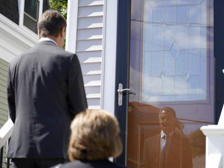 Dan Sideris is reflected in a front storm door Thursday as he and his wife, Carrie Sideris, of Newton, Mass., return to door-to-door visits as Jehovah's Witnesses in Boston. After more than two and a half years on hiatus due to the coronavirus pandemic, members are reviving a religious practice that the faith considers crucial and cherished.