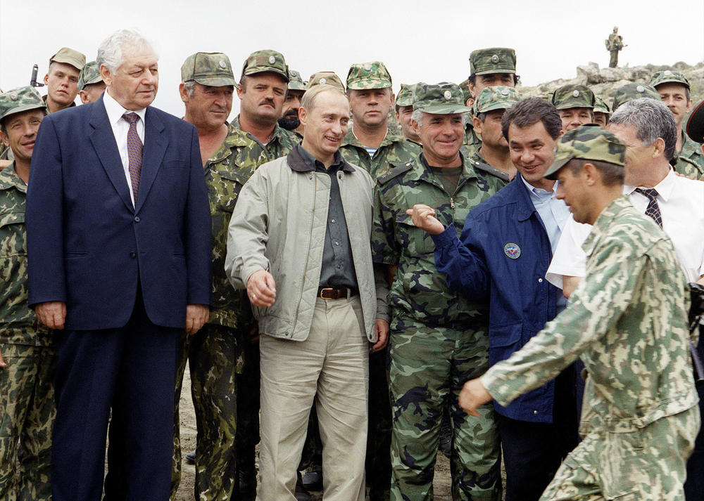 Russian Prime Minister Vladimir Putin (second from left in foreground), and Dagestani leader Magomedali Magomedov (left) visit Russian troops at a military base in the mountains of the Botlikh region, Dagestan, following Chechen attacks in Dagestan, on Aug. 27, 1999. Russian forces entered Chechnya weeks after the attacks, starting the second of two post-Soviet wars in the mostly Muslim region.