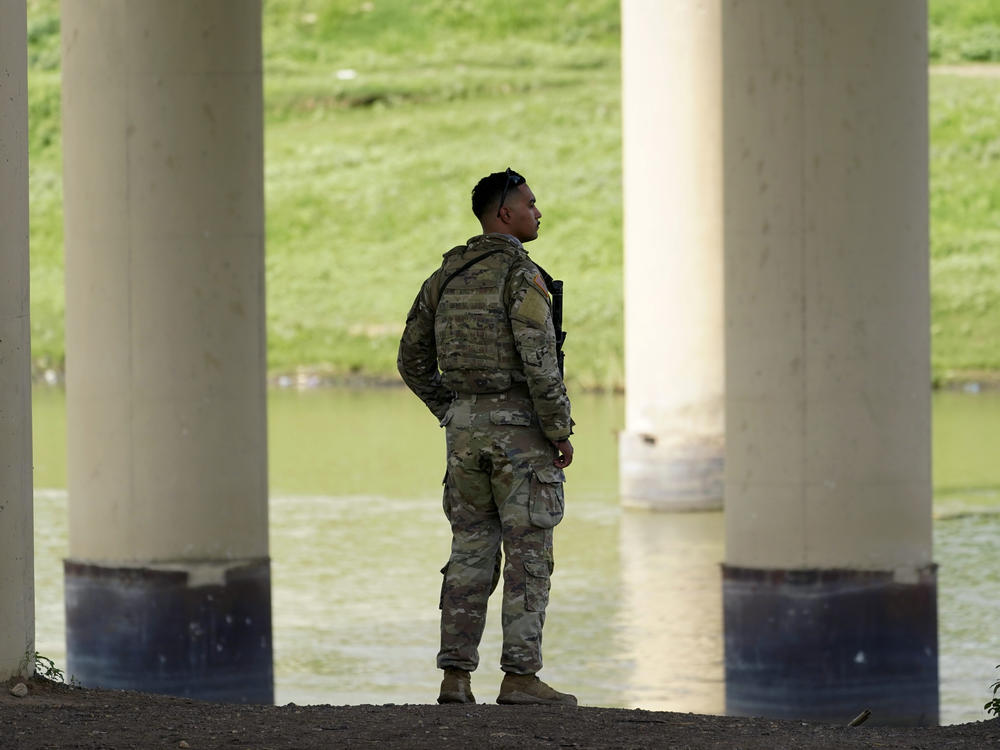 A member of the Texas National Guard looks across the Rio Grande to Mexico from the U.S. at Eagle Pass, Texas, on Aug. 26.