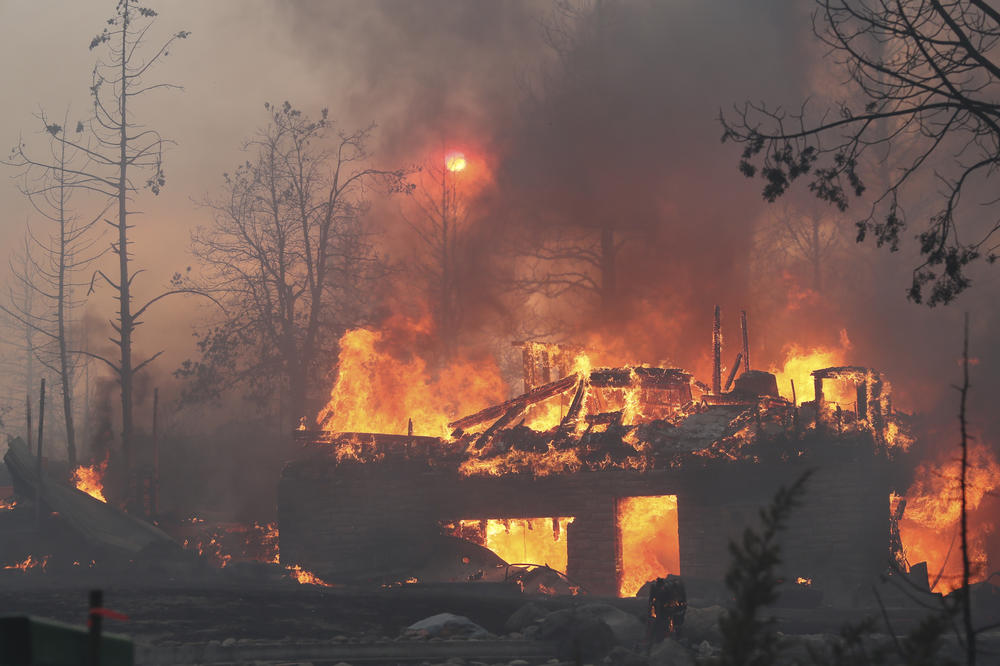 A residence goes up in flames as the Mill Fire causes damage in the Lake Shastina subdivision northwest of Weed, Calif., on Friday.