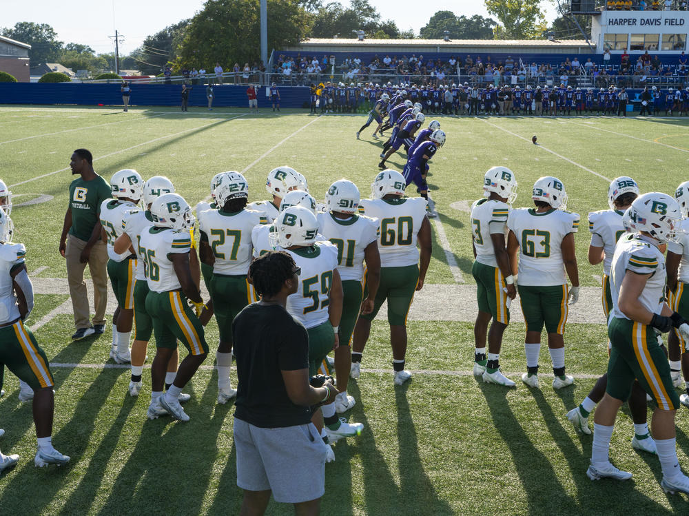 The Belhaven University football team stands on the sidelines as their game against Millsaps College begins on Thursday.
