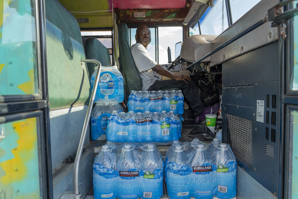 Kevin Edwards delivers free water to residents from a repurposed school bus at the Westland Plaza Parking Lot in Jackson, Mississippi, on Friday.